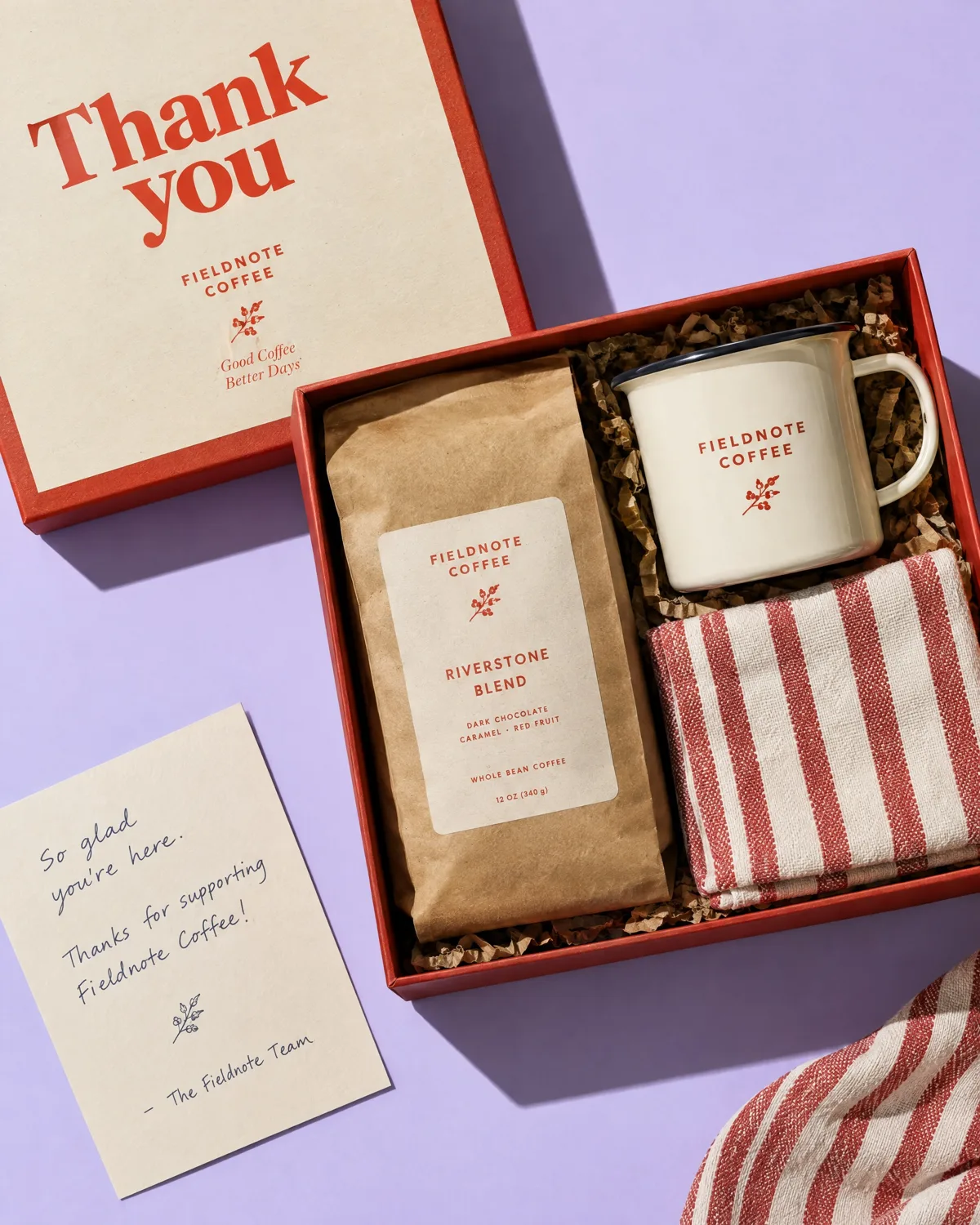 Thank-you gift box with coffee, a mug, a striped towel and a handwritten card
